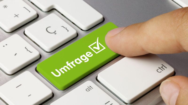 Ein Zeigefinger drückt auf einer Tastatur auf eine grüne Taste mit der Aufschrift 